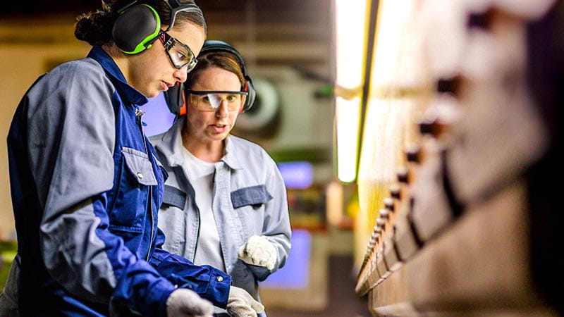 Zwei Frauen arbeiten am Band in einer Fabrik - wie krisenfest ist mein Beruf? Zwei Frauen arbeiten am Band in einer Fabrik - wie krisenfest ist mein Beruf?
